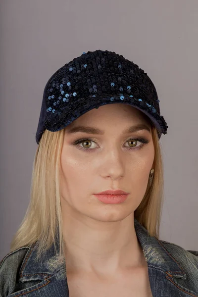 Beautiful girl with natural make-up in a headdress on a gray background. — Stock Photo, Image