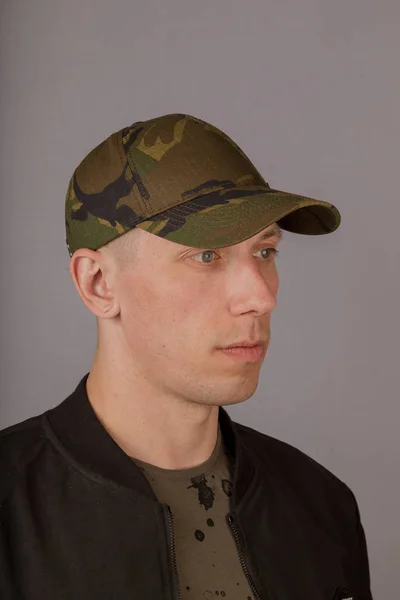 Handsome young man in a headdress on a gray background. — Stock Photo, Image