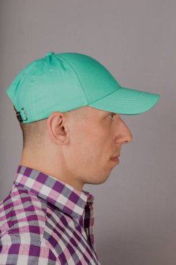 Gri bir arka plan üzerinde bir başlık yakışıklı genç adam.