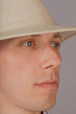 Gri bir arka plan üzerinde bir başlık yakışıklı genç adam.