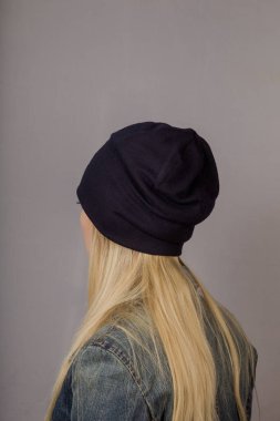 Gri bir arka plan üzerinde doğal makyaj ile şık bir başlık güzel bir genç kız Portresi.