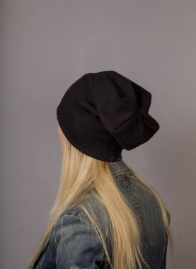 Gri bir arka plan üzerinde doğal makyaj ile şık bir başlık güzel bir genç kız Portresi.