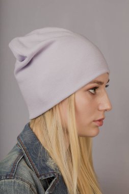 Gri bir arka plan üzerinde doğal makyaj ile şık bir başlık güzel bir genç kız Portresi.