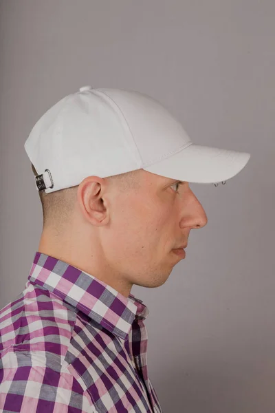 Joven guapo con un tocado sobre un fondo gris . — Foto de Stock