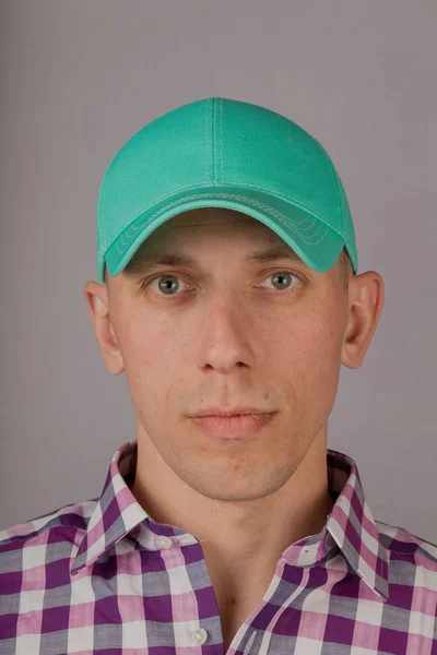 Handsome young man in a headdress on a gray background. — Stock Photo, Image