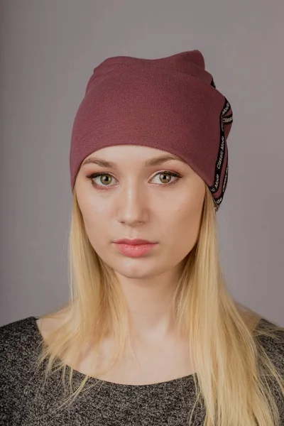 Portrait of a beautiful young girl in a stylish headdress with natural makeup on a gray background. — Stock Photo, Image