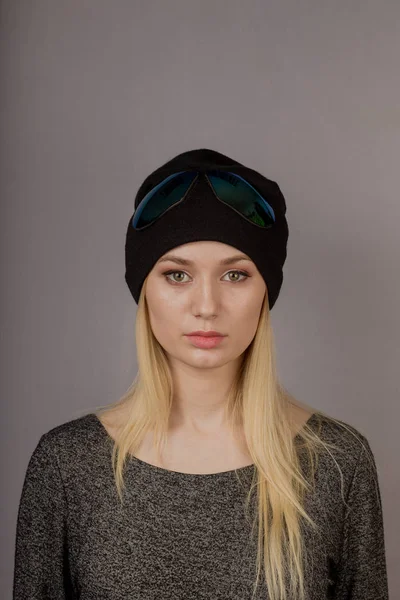 Портрет красивой молодой девушки в стильном головном уборе с натуральным макияжем на сером фоне . — стоковое фото