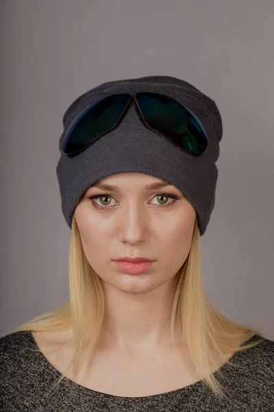 Portrait of a beautiful young girl in a stylish headdress with natural makeup on a gray background. — Stock Photo, Image