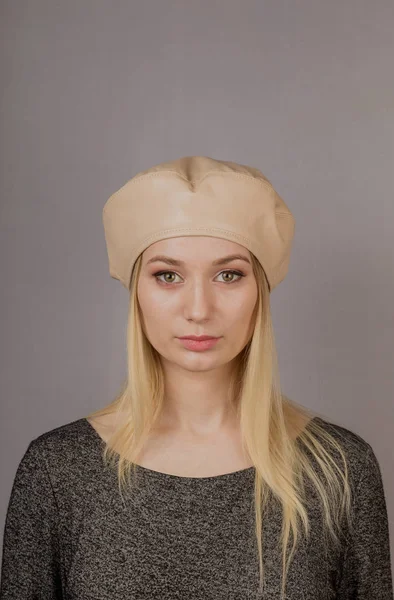 Portrait of a beautiful young girl in a stylish headdress with natural makeup on a gray background. — Stock Photo, Image