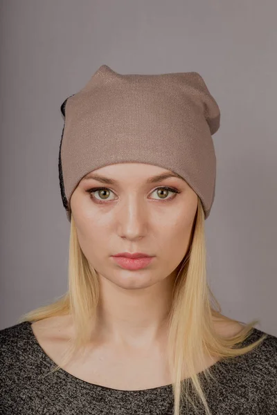 Portrait of a beautiful young girl in a stylish headdress with natural makeup on a gray background. — Stock Photo, Image