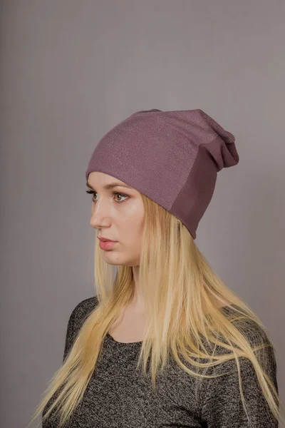 Portrait of a beautiful young girl in a stylish headdress with natural makeup on a gray background. — Stock Photo, Image