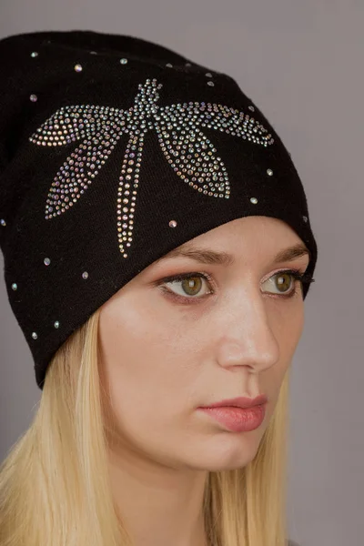 Portrait of a beautiful young girl in a stylish headdress with natural makeup on a gray background. — Stock Photo, Image