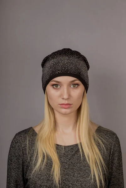 Portrait of a beautiful young girl in a stylish headdress with natural makeup on a gray background. — Stock Photo, Image