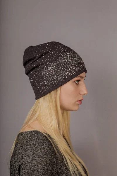 Portrait of a beautiful young girl in a stylish headdress with natural makeup on a gray background. — Stock Photo, Image