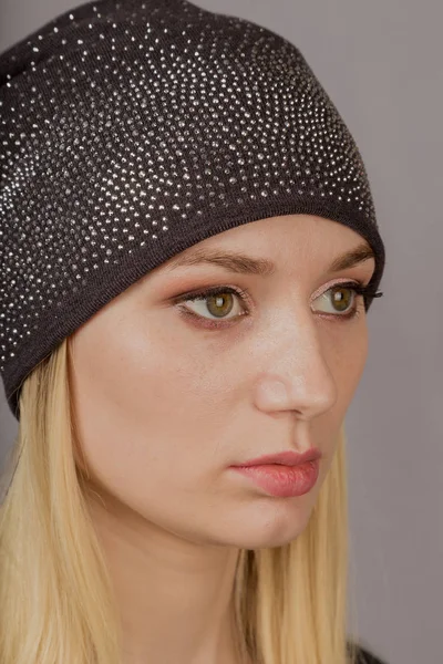 Portrait of a beautiful young girl in a stylish headdress with natural makeup on a gray background. — Stock Photo, Image