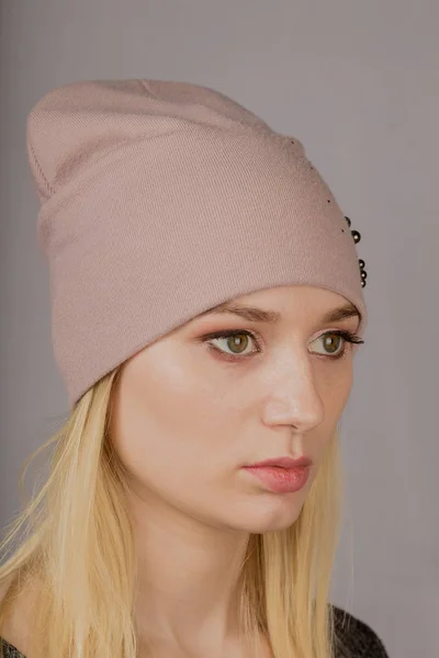 Portrait of a beautiful young girl in a stylish headdress with natural makeup on a gray background. — Stock Photo, Image