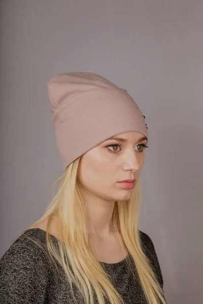 Portrait of a beautiful young girl in a stylish headdress with natural makeup on a gray background. — Stock Photo, Image