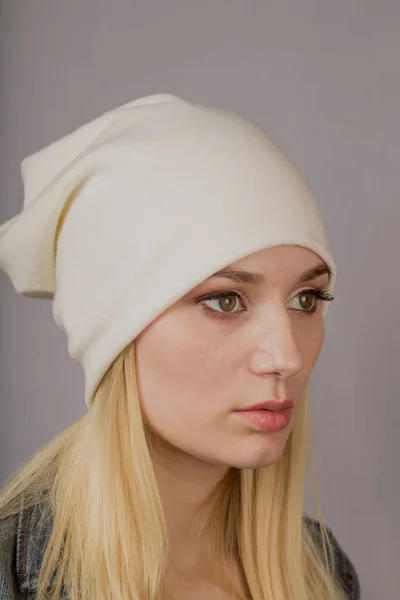 Portrait of a beautiful young girl in a stylish headdress with natural makeup on a gray background. — Stock Photo, Image