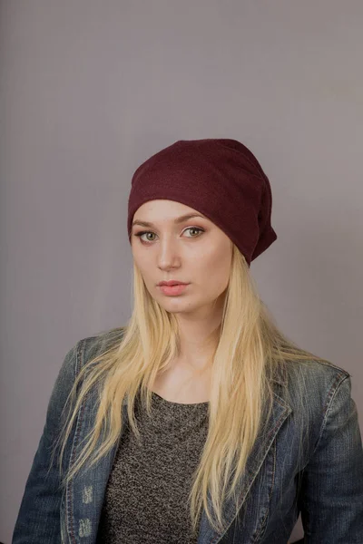 Portrait of a beautiful young girl in a stylish headdress with natural makeup on a gray background. — Stock Photo, Image