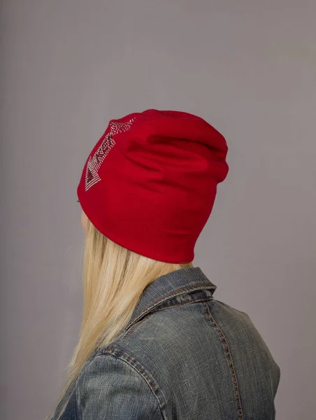 Portret van een mooi jong meisje in een stijlvolle hoofdtooi met natuurlijke make-up op een grijze achtergrond. — Stockfoto