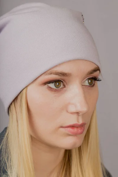 Portrett av en vakker ung jente med stilig hodeplagg og naturlig sminke på grå bakgrunn . – stockfoto