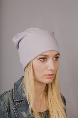 Gri bir arka plan üzerinde doğal makyaj ile şık bir başlık güzel bir genç kız Portresi.