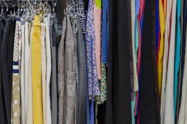 Askıları bir mağazada güzel renkli giysiler.
