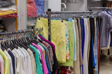 Askıları bir mağazada güzel renkli giysiler.