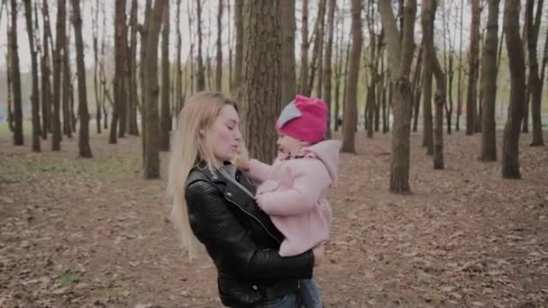 Piękna matka trzyma dziewczynę w ramionach w parku. — Wideo stockowe