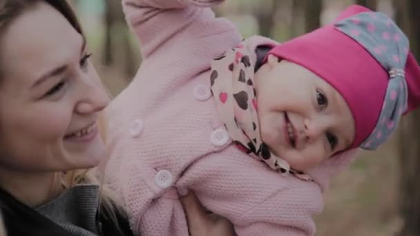 Красивая мать держит девушку на руках в парке . — стоковое видео