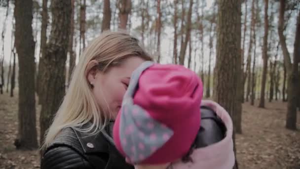 美丽的母亲抱着一个女孩在公园里. — 图库视频影像