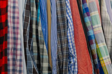 Askıları bir mağazada güzel renkli giysiler.