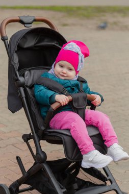 Sokakta bir bebek arabası oturan küçük kız