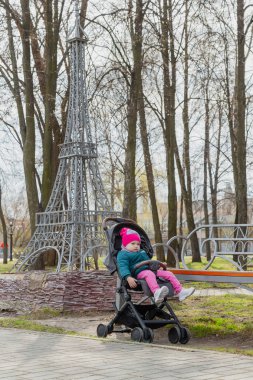 Sokakta bir bebek arabası oturan küçük kız