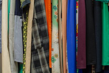 Askıları bir mağazada güzel renkli giysiler.