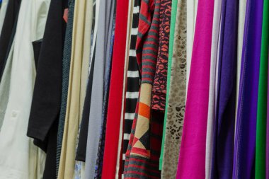 Askıları bir mağazada güzel renkli giysiler.