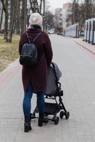 Девушка гуляет в парке с детской коляской . — стоковое фото