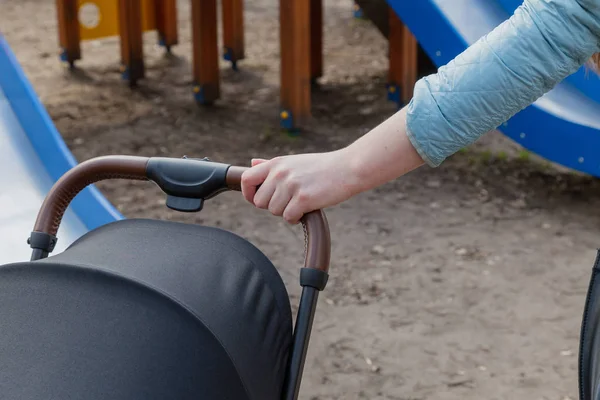 Девочка держит детскую коляску с ребенком рано утром . — стоковое фото