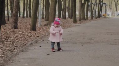 Güzel küçük kız parkta yalnız yürüyor.