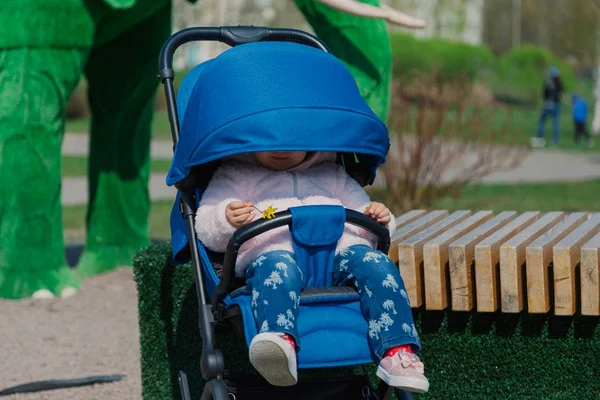 Little beautiful girl sitting in the stroller. — Stock Photo, Image