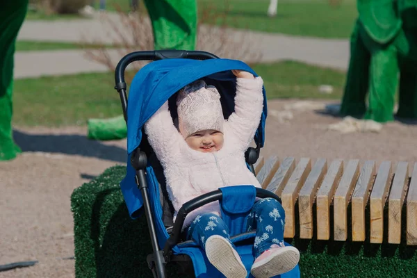 Little beautiful girl sitting in the stroller. — Stock Photo, Image