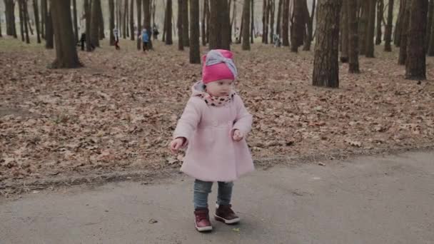 Красивая маленькая девочка гуляет одна в парке . — стоковое видео