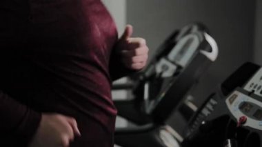 Spor salonunda koşu bandı üzerinde Yetişkin kilolu adam.