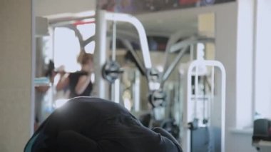Kilolu yetişkin bir adam bir spor salonunda hiperuzantısı gerçekleştirir.