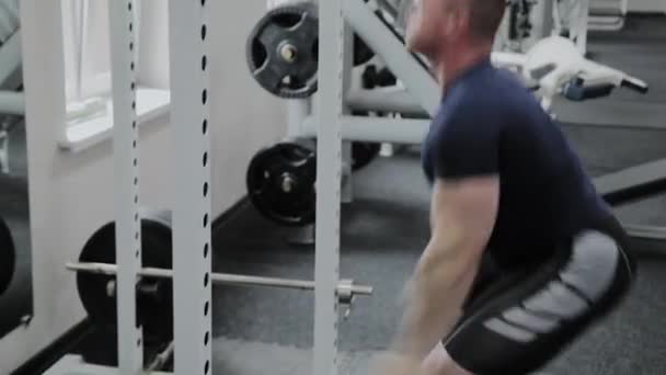 Uomo atletico esegue squat di velocità in palestra . — Video Stock