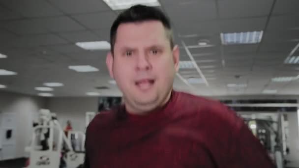 Hombre adulto con sobrepeso en la cinta de correr en el gimnasio . — Vídeos de Stock