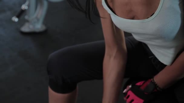 Mladá aktivní dívka zdvihá činku pro sedící biceps. — Stock video