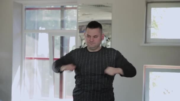 Übergewichtiger erwachsener Mann wärmt sich im Fitnessstudio auf. — Stockvideo