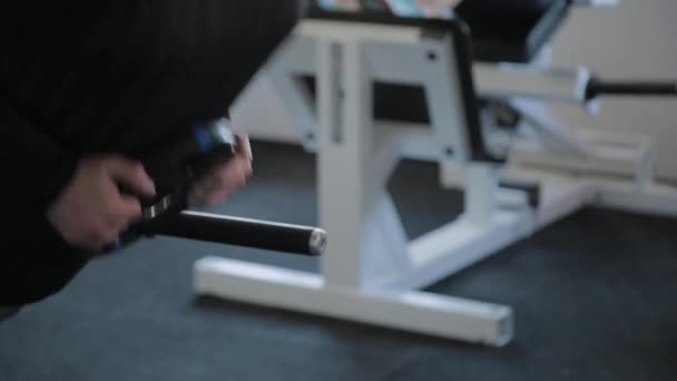 En övervikt vuxen man utför översträckning i ett gym. — Stockvideo