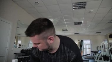 Kilolu yetişkin adam spor salonunda deadlift gerçekleştirir.
